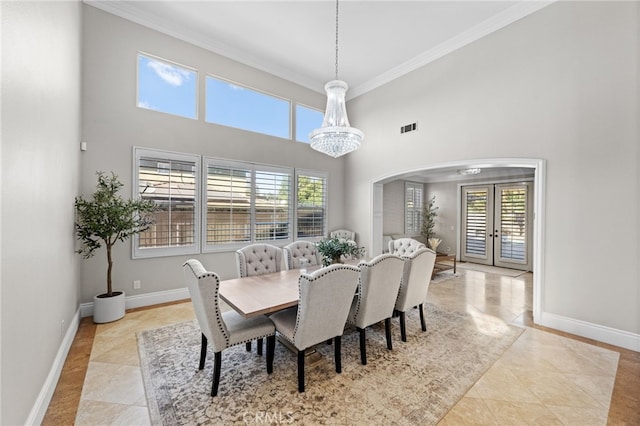 tiled dining room featuring ornamental molding, french doors, and a high ceiling