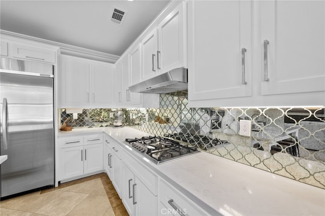 kitchen with appliances with stainless steel finishes, tasteful backsplash, white cabinetry, light tile patterned floors, and light stone counters