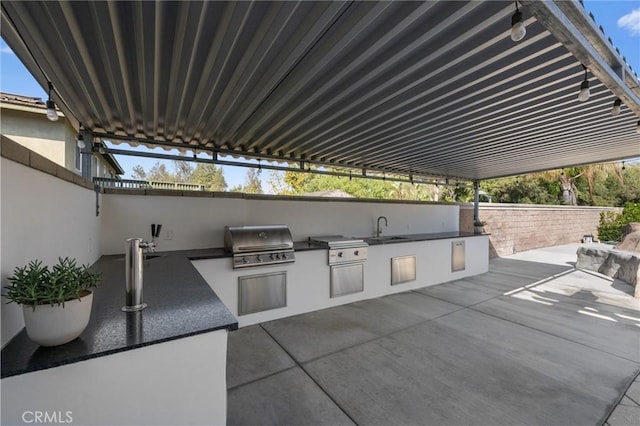 view of patio with an outdoor kitchen, a grill, and sink