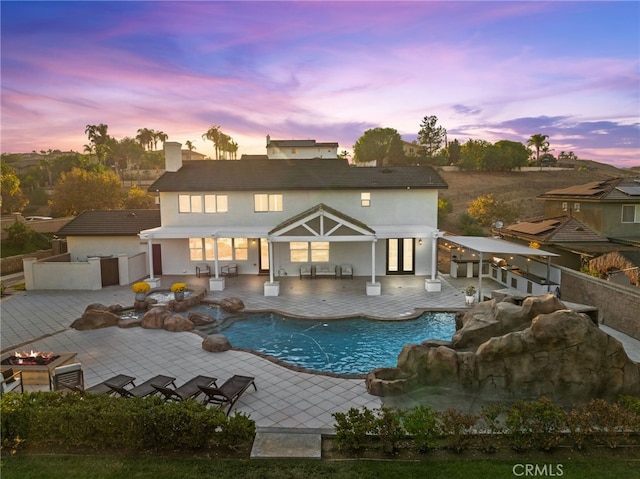 pool at dusk with a patio