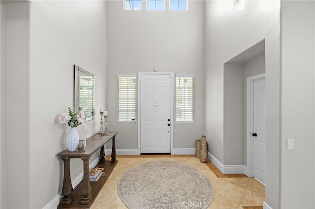 tiled foyer featuring a towering ceiling