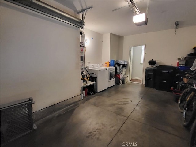 garage with a garage door opener and washing machine and clothes dryer