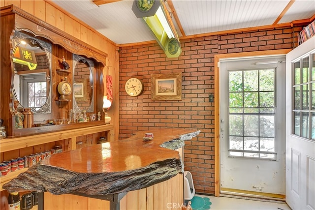 dining area with wooden walls and brick wall