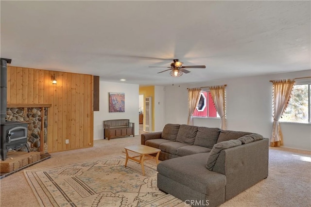 9226 La Porte Rd, Brownsville, CA 95919 - living area with wooden walls, a wood stove, baseboards, light colored carpet, and ceiling fan