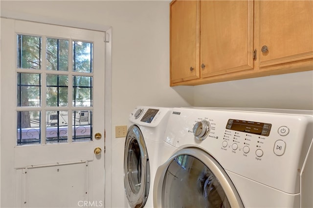 washroom featuring cabinets and washer and clothes dryer