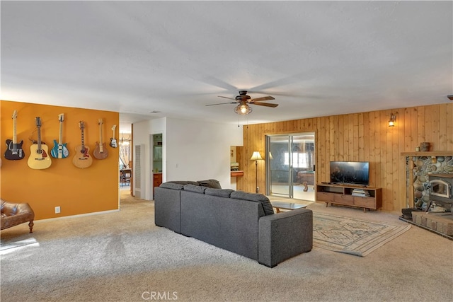 carpeted living room with wooden walls and ceiling fan