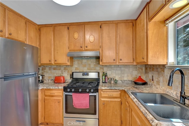 kitchen featuring light stone countertops, stainless steel appliances, backsplash, and sink