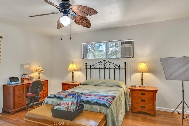 bedroom featuring light wood-type flooring, a wall mounted AC, and ceiling fan