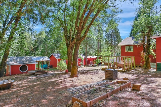 view of yard featuring a wooden deck and a shed