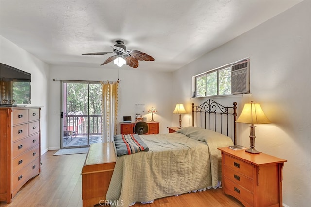 bedroom featuring light hardwood / wood-style flooring, an AC wall unit, ceiling fan, and access to exterior