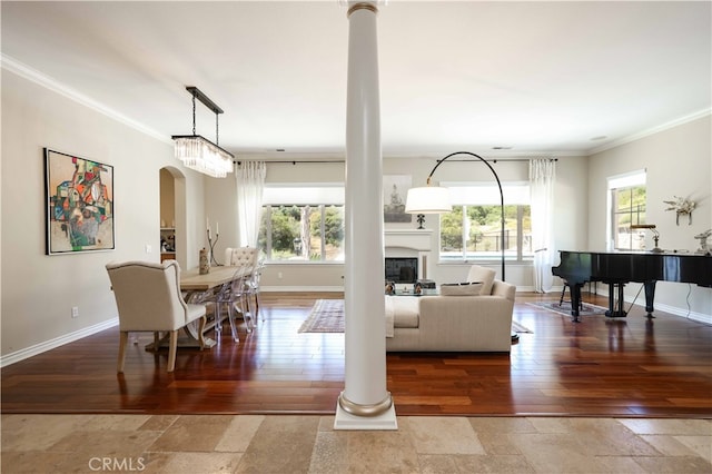 living room with ornate columns, hardwood / wood-style flooring, plenty of natural light, and crown molding