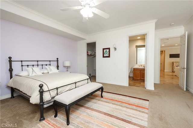 bedroom with ceiling fan, crown molding, a closet, a spacious closet, and ensuite bath