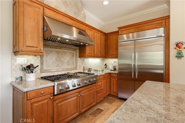 kitchen with tasteful backsplash, wall chimney exhaust hood, light stone countertops, stainless steel appliances, and ornamental molding