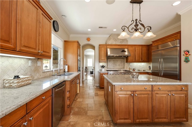 kitchen with hanging light fixtures, sink, extractor fan, stainless steel appliances, and a center island