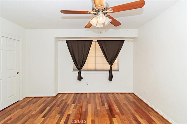 spare room with dark hardwood / wood-style floors and ceiling fan