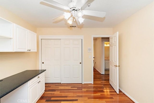 kitchen with white cabinetry, dark hardwood / wood-style flooring, and ceiling fan