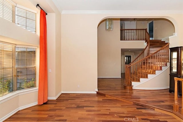 foyer featuring hardwood / wood-style floors, a wealth of natural light, and crown molding