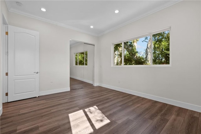 empty room with dark hardwood / wood-style flooring and ornamental molding