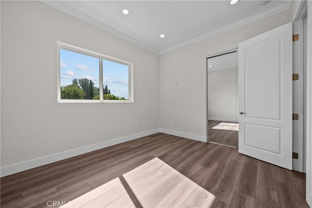 unfurnished bedroom with crown molding and dark hardwood / wood-style flooring