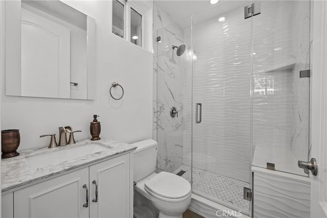 bathroom featuring vanity, toilet, and a shower with shower door