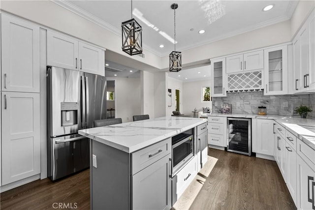 kitchen featuring appliances with stainless steel finishes, white cabinetry, and beverage cooler