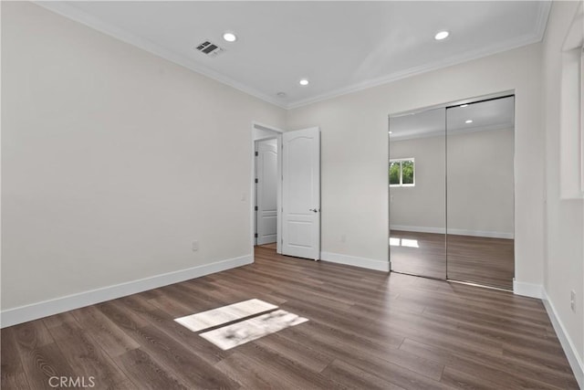 unfurnished bedroom featuring crown molding, dark wood-type flooring, and a closet