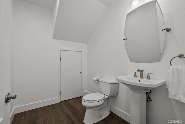 bathroom featuring sink, wood-type flooring, lofted ceiling, and toilet