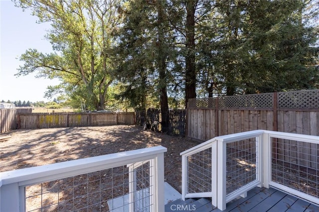 wooden terrace with a fenced backyard