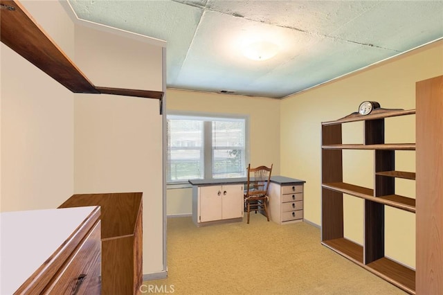 unfurnished office with light carpet, visible vents, and baseboards