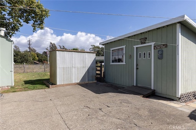 view of outbuilding featuring an outdoor structure and fence