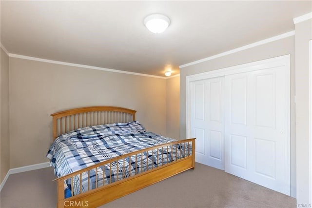 bedroom featuring carpet floors, crown molding, baseboards, and a closet