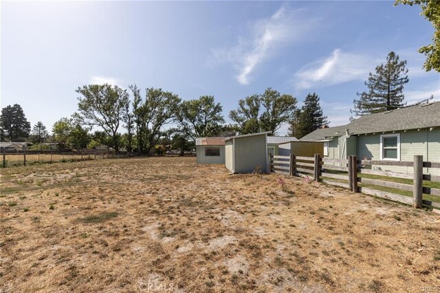 view of yard with an outbuilding and fence