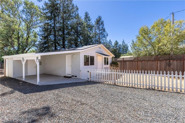 view of front of property featuring a patio, fence private yard, and stucco siding