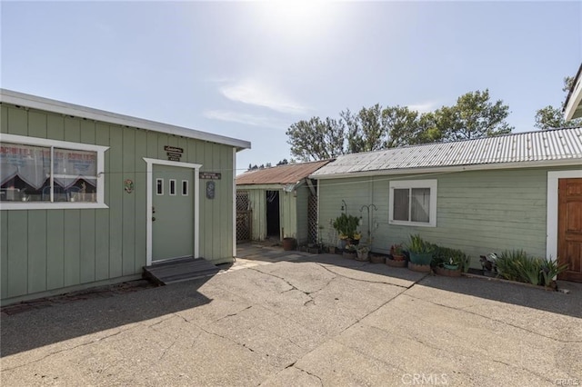 back of property with a patio area and metal roof