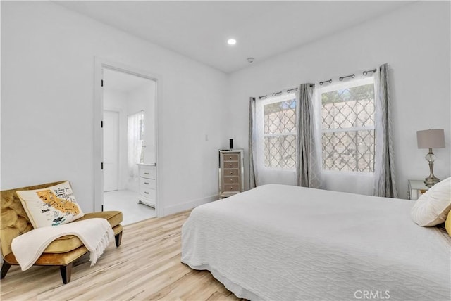 bedroom featuring hardwood / wood-style floors and ensuite bathroom