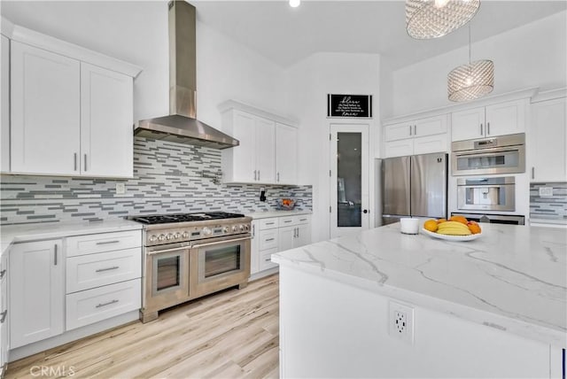 kitchen with white cabinetry, stainless steel appliances, and wall chimney range hood