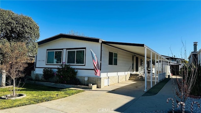 view of front of property with driveway, a carport, and crawl space