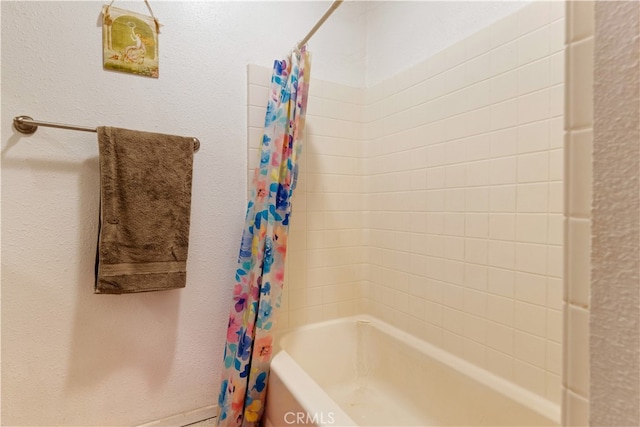 bathroom with shower / bath combo with shower curtain