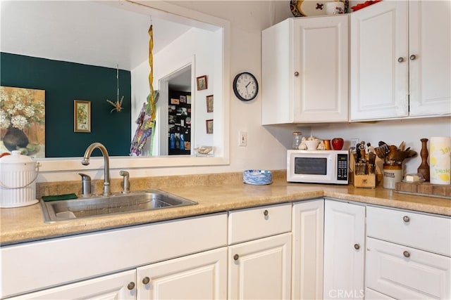 kitchen featuring sink and white cabinets