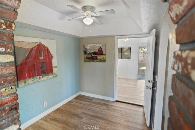 interior space with ceiling fan, a textured ceiling, and hardwood / wood-style floors