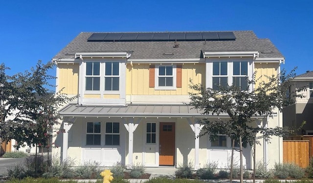 view of front of property featuring solar panels and a porch