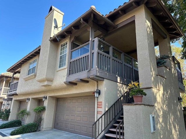 view of property exterior featuring a balcony and a garage