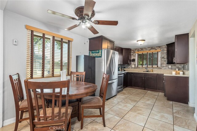 kitchen featuring ceiling fan, dark brown cabinetry, sink, appliances with stainless steel finishes, and decorative backsplash