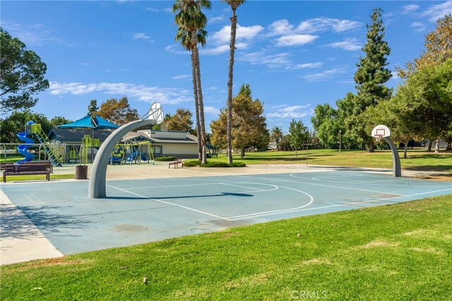 view of sport court with a playground and a lawn