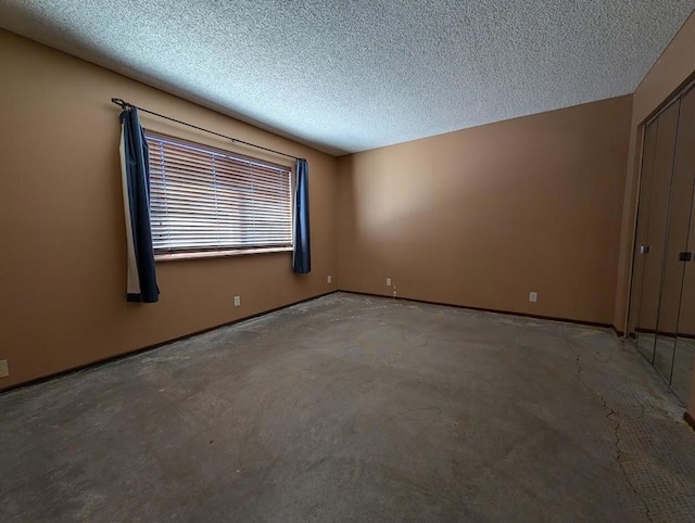 spare room featuring concrete flooring and a textured ceiling