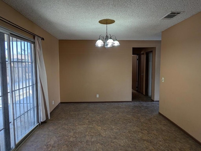 empty room with a textured ceiling and a notable chandelier