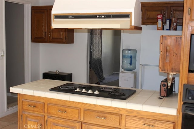 kitchen with exhaust hood, tile countertops, tile patterned floors, and black electric stovetop