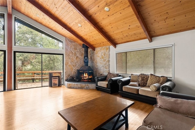 living room with beam ceiling, a wood stove, wood-type flooring, high vaulted ceiling, and wooden ceiling