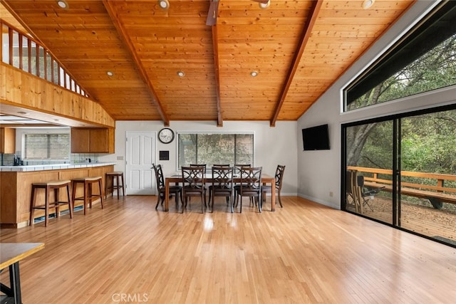 dining room with light wood-type flooring, high vaulted ceiling, and plenty of natural light