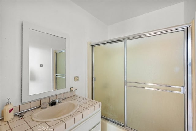 bathroom with tile patterned flooring, combined bath / shower with glass door, and vanity